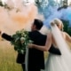 Brautpaar bei Fotoshooting mit bunten Rauchfackeln