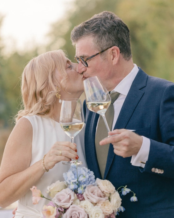 Kuss Hochzeitspaar mit Weingläsern in der Hand